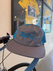 Gray cap with blue brim and embroidered logo on a bicycle