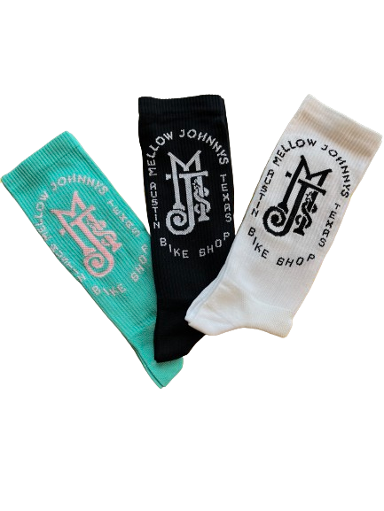 Three socks laid out flat with different colors and logos. One is black with a white logo, one is white with a black logo, and one is a solid teal color.