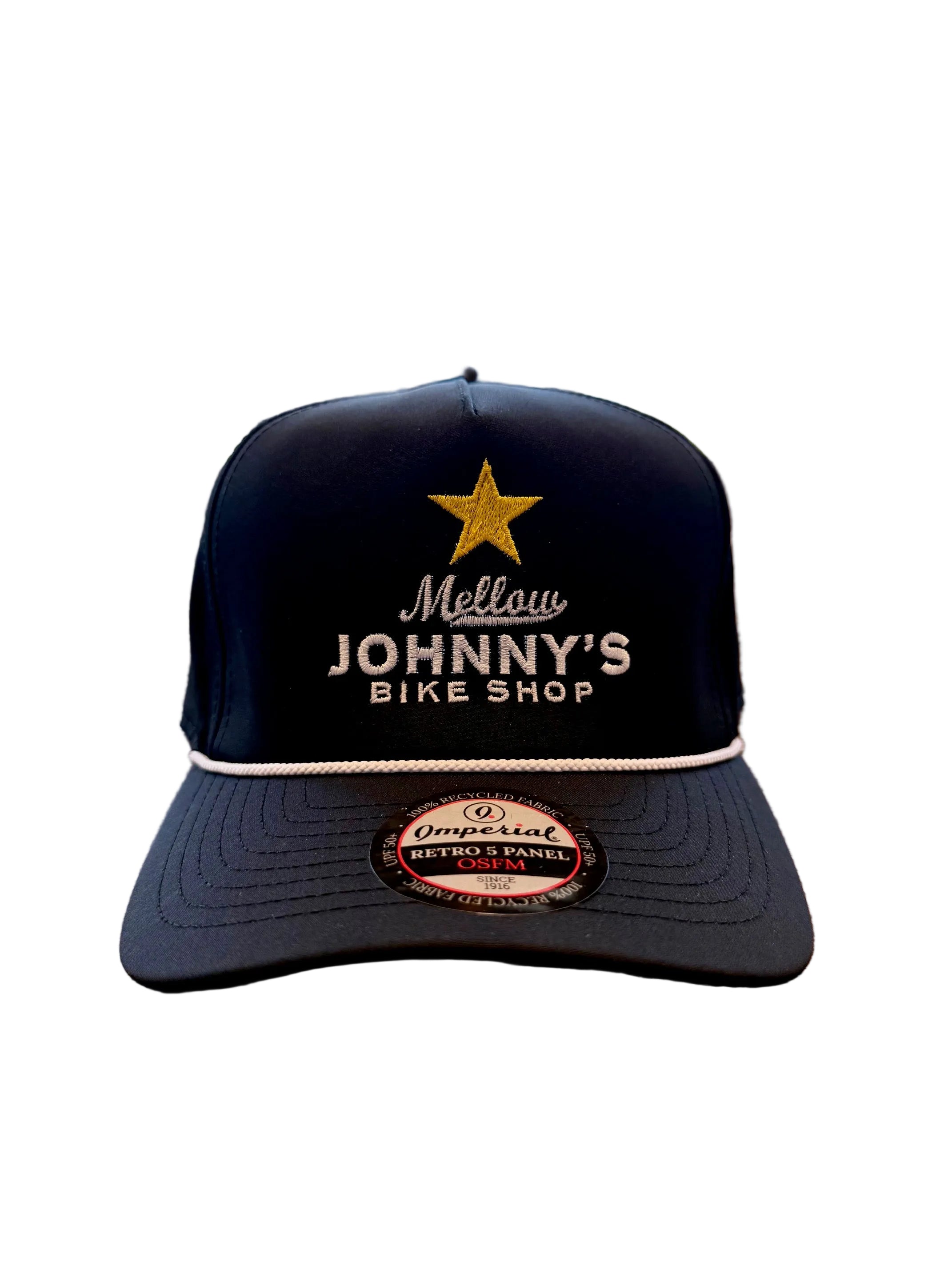 Black cap with 'Mellow Johnny's Bike Shop' logo on a wooden surface with bicycles in the background
