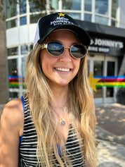 A person wearing a white and black 6 panel mesh snapback trucker hat with 'MELLOW JOHNNY'S' branding on the front.