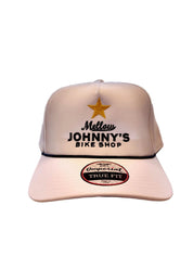 White cap with 'Mellow Johnny's Bike Shop' logo on a wooden surface with bicycles in the background