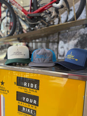 Three hats on a yellow surface with a bike in the background